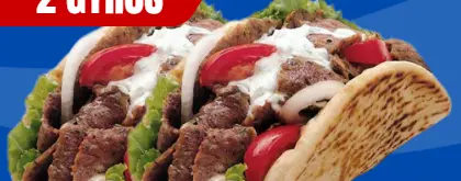 Two gyros with lettuce, tomato, onion and sauce